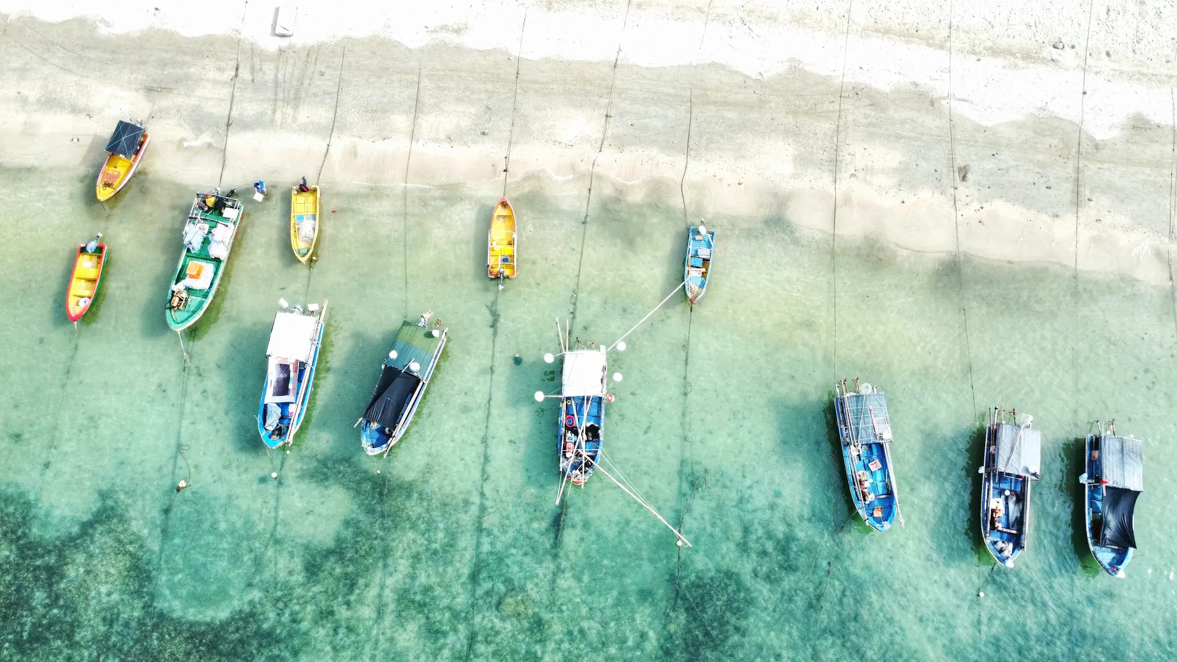 Fishing boats moored in clear turquoise water off Sanya, seen from above